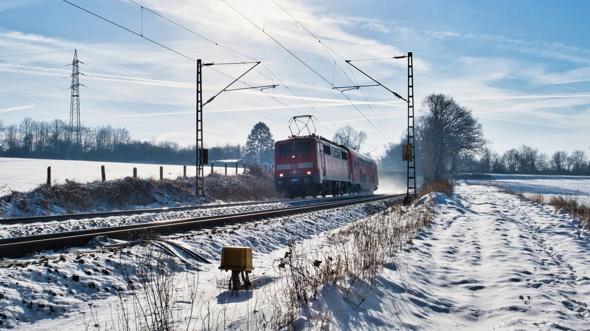 111 137 mit Überführungszug im Gegenlicht