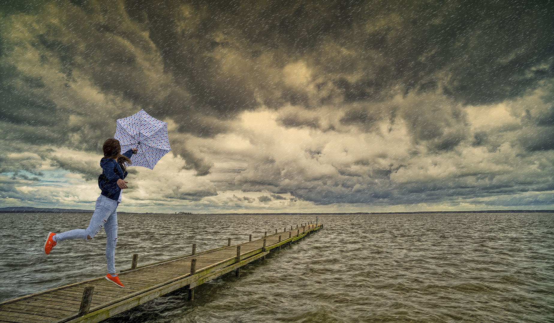1286TZ Frau mit Schirm auf Steg Steinhude am Meer  stürmisch und regnerisch