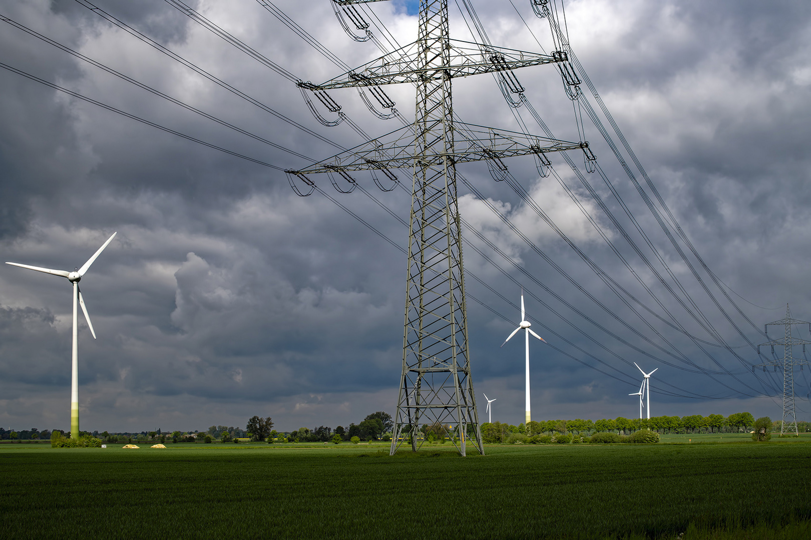 1543SC Windräder mit Stromleitungen und dramatischer Himmel