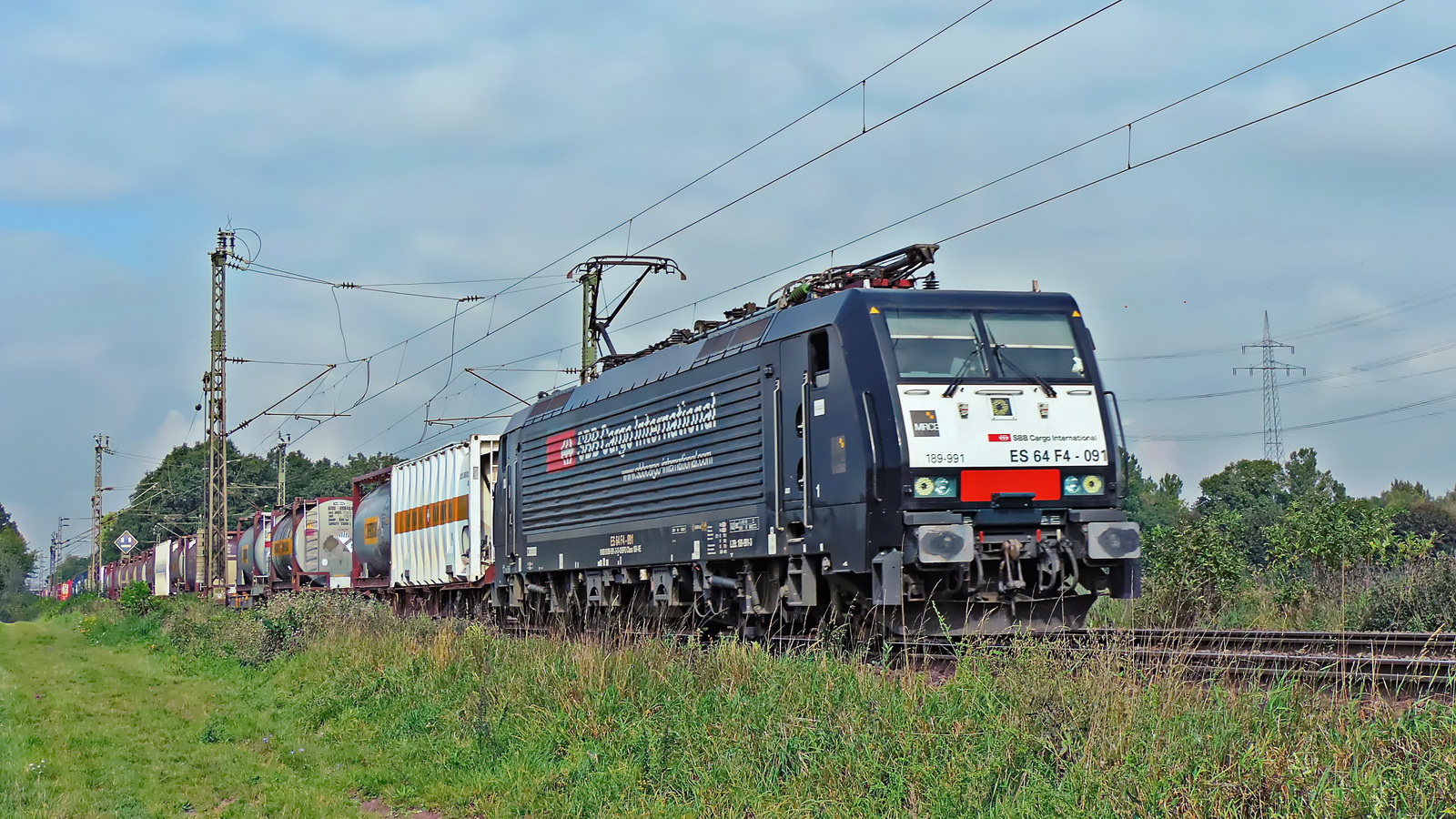 189 991 ES 64 F4-091 MRCE SBB International vor einem gem. Güterzug