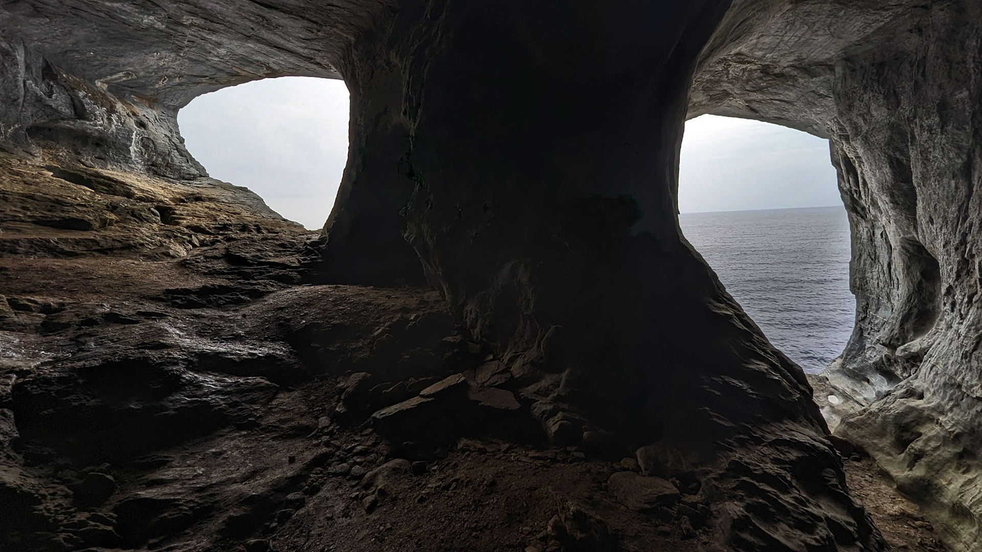 2 Öffnungen in der Felswand zum Meer