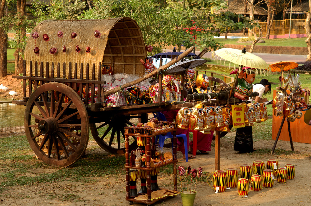 2) Young lady displaying some colourful local craft in Myanmar (Burma) Story within.