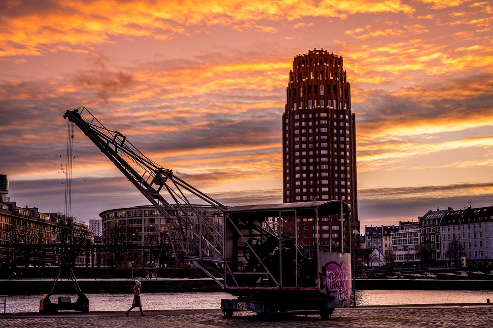 2021 Spaziergängerin am Mainufer in Frankfurt im Abendrot