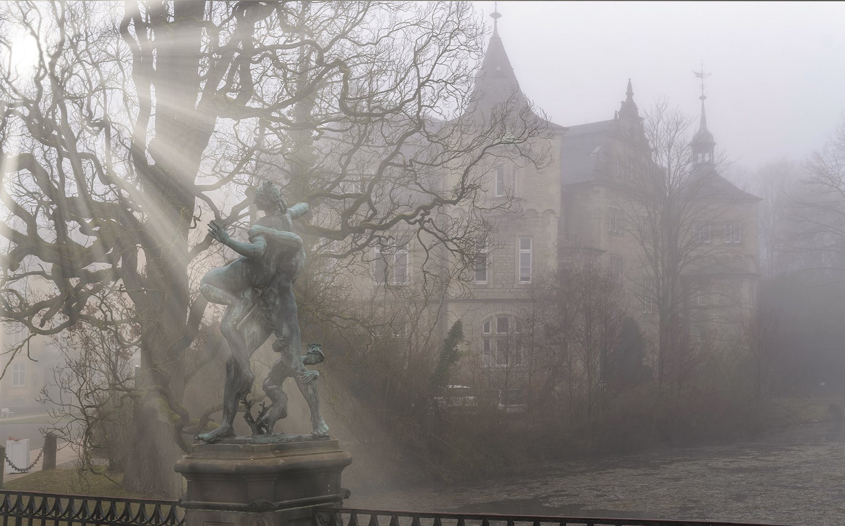 2687SC Schloss Bückeburg im Nebel mit Figur von De Vries mit Sonne