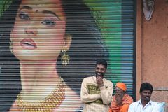 3 Maenner vor Plakat in Kerala-Indien