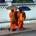 3 monks under their umbrella