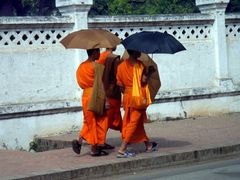 3 monks under their umbrella