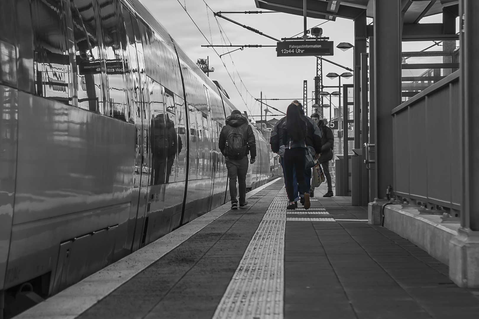 4 Menschen auf dem Bahnsteig