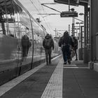 4 Menschen auf dem Bahnsteig