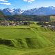 Idyllisches Dorf mit Panoramablick auf die schneebedeckten Berge