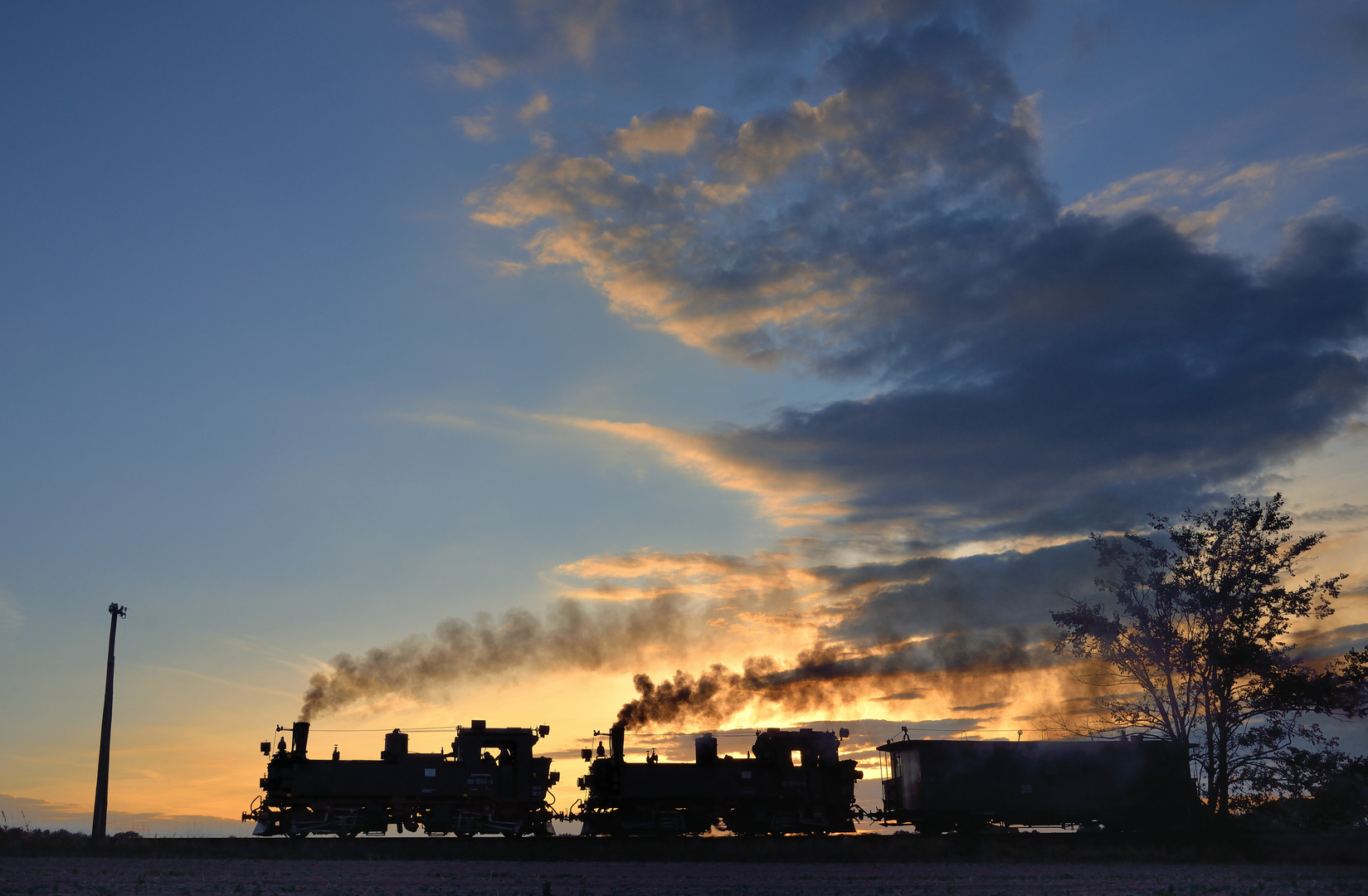 99 1584-4 + 99 1574-5 mit Packwagen am 14.09.18 bei Naundorf im Sonnenuntergang