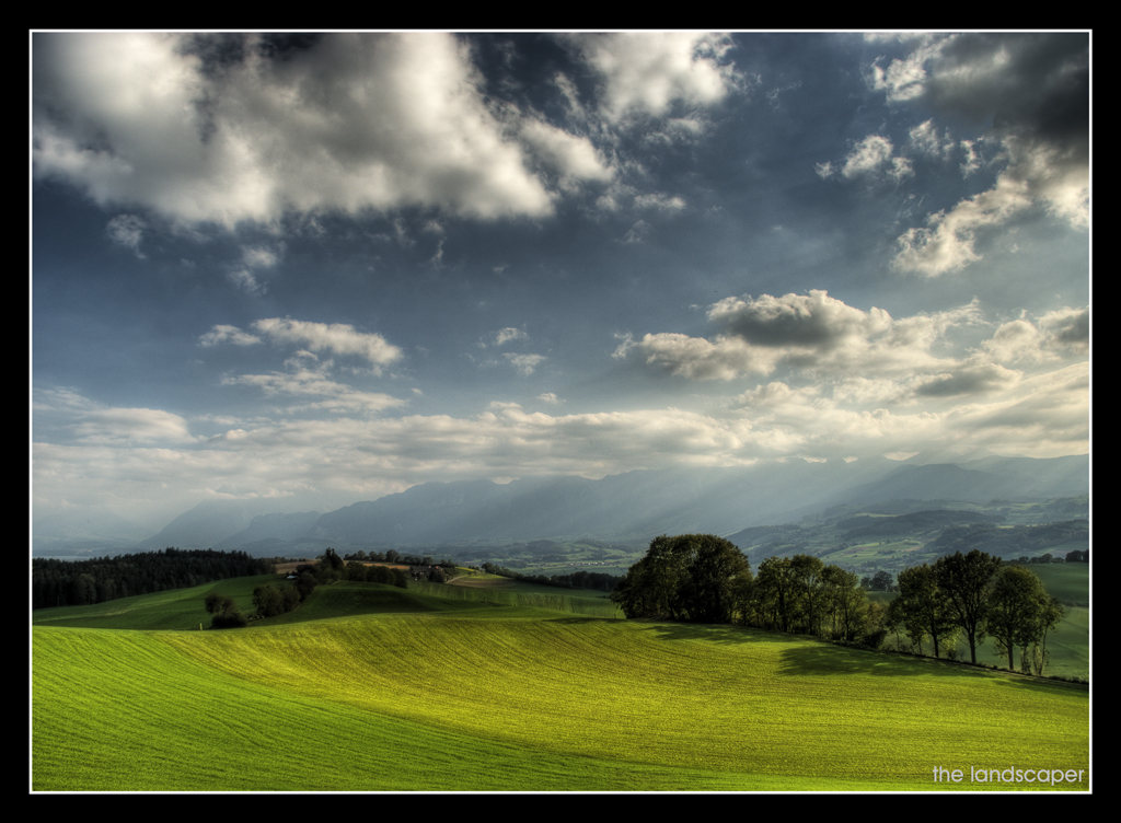 a big sky and a green field