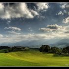 a big sky and a green field