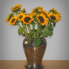 A bouquet of sunflowers in a silver vase