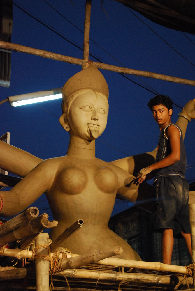 a boy making a 12 feet tall idol of goddess