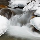 A detail of an icy mountain stream