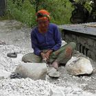 A GARHWAL WOMAN BREAKING STONES