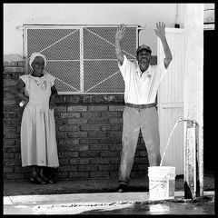 A Lady - watching a man singing and dancing while filling his bucket!