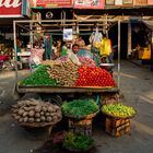 A local vendor prepares a display of vegetables.