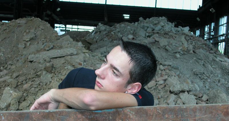 a man in front of the rubbles of his life