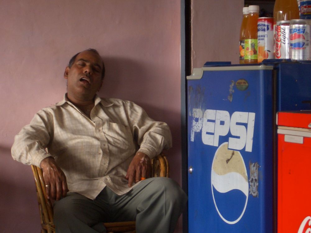 A quick nap during work, Rishikesh - India by Roland Claus