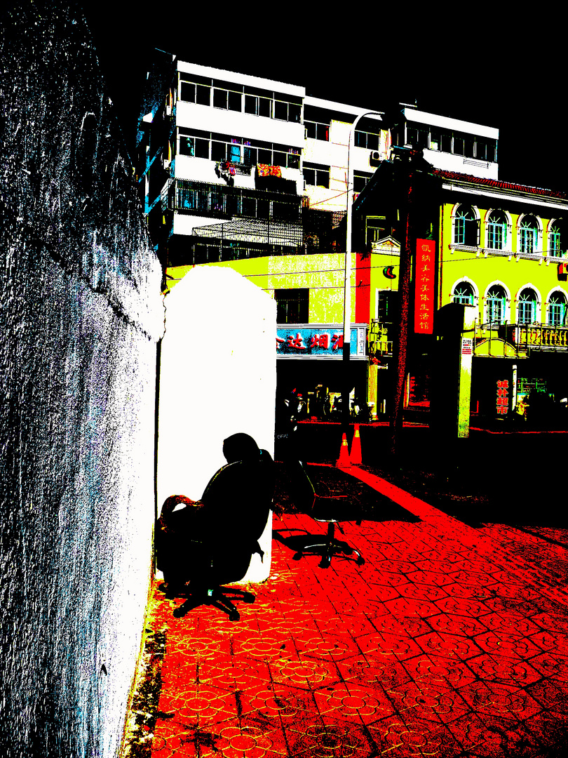 A street in china with woman sleeping on a chair