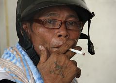 A tatooed protester of the Reds mit helmet after fleeing the camp in Central Bangkok.