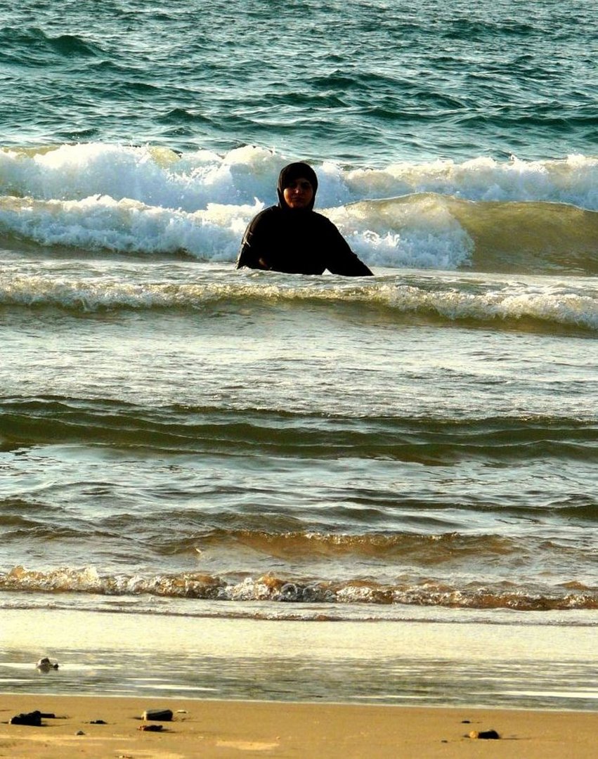 A woman in burqa in the sea, Tel Aviv, Israel