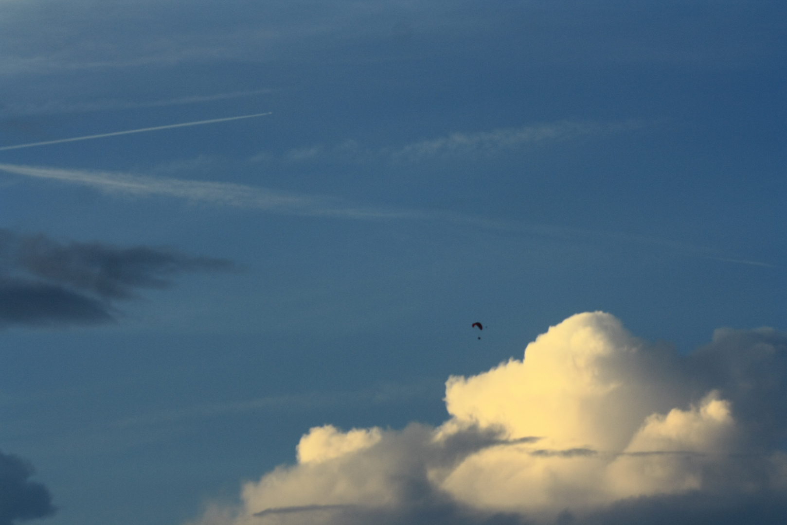 Abendhimmel mit Drachenflieger und Kondensstreifen