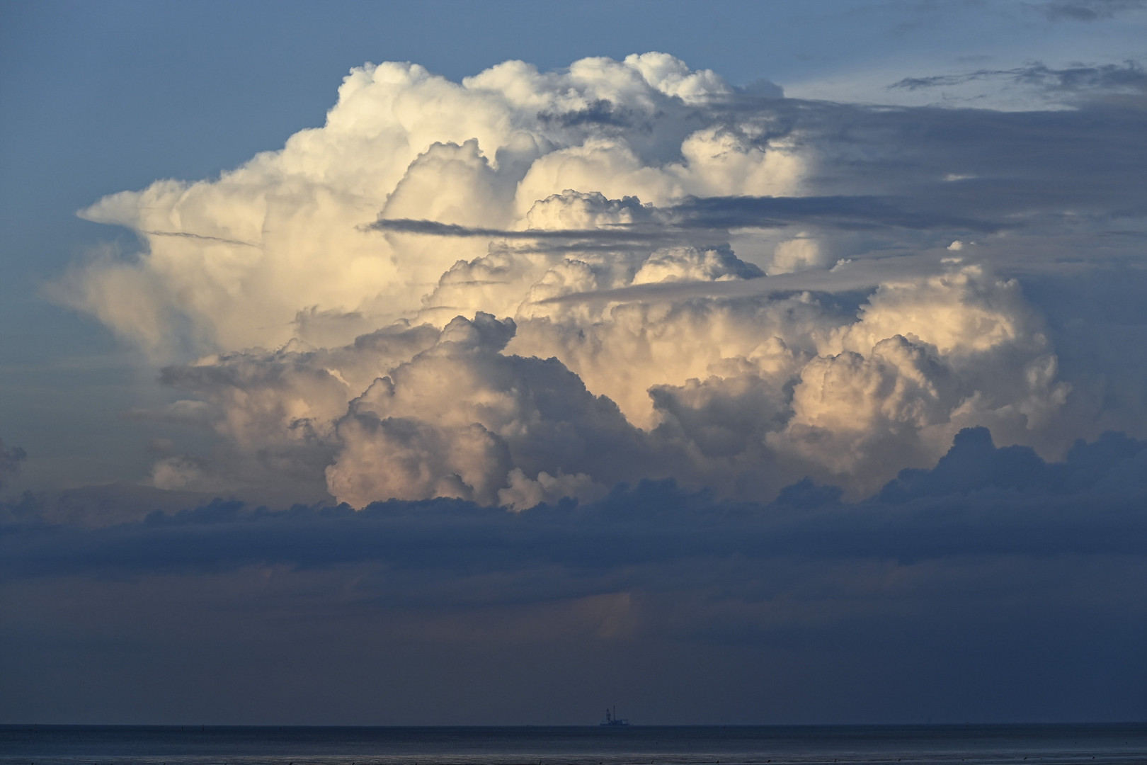 Abendlicher Gewitterkumulus über der Aussenelbe, am Horizont die Bohrplattform Mittelplate.