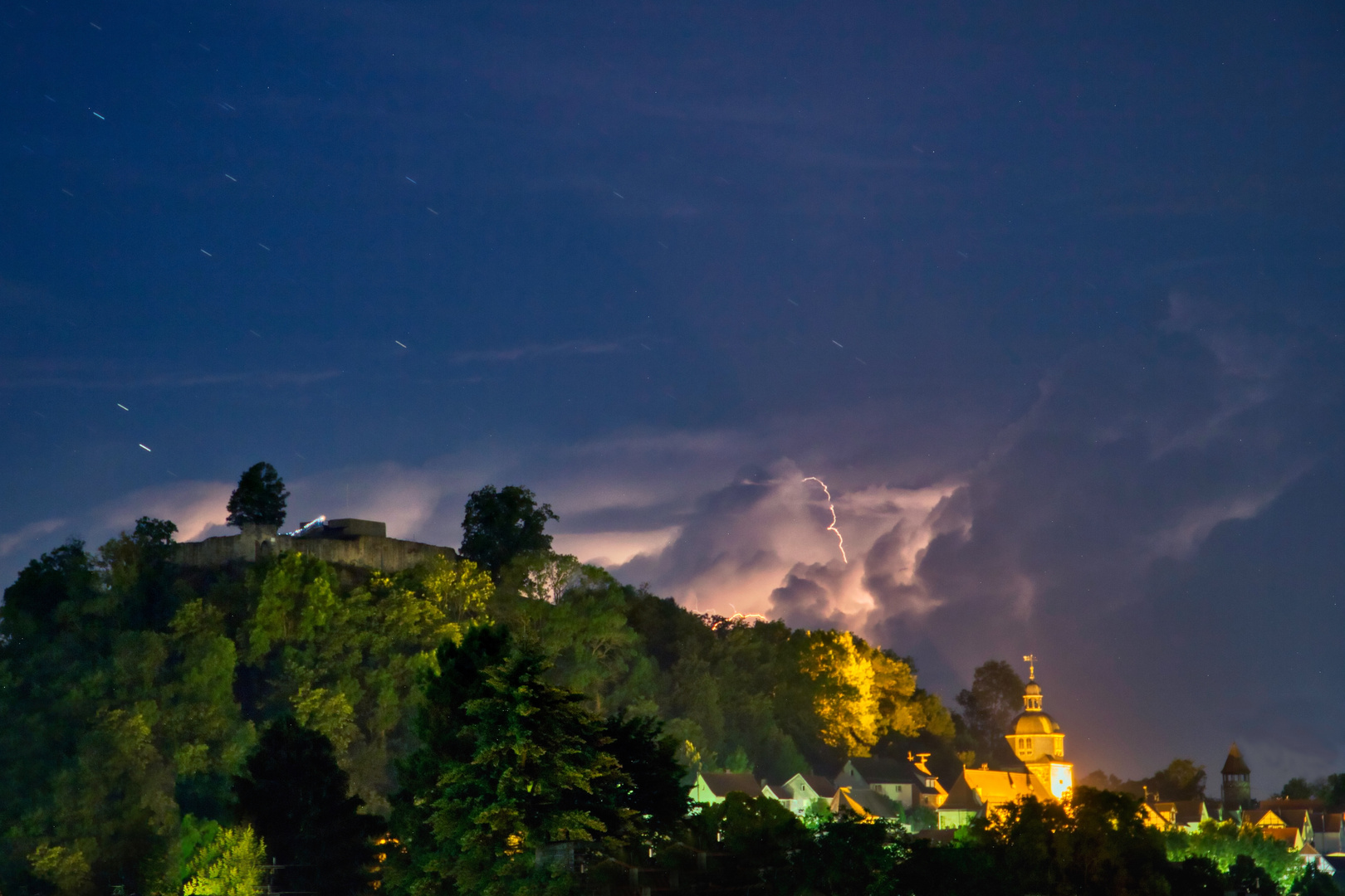 Abendliches Gewitter mit Blitzen und Startrails.