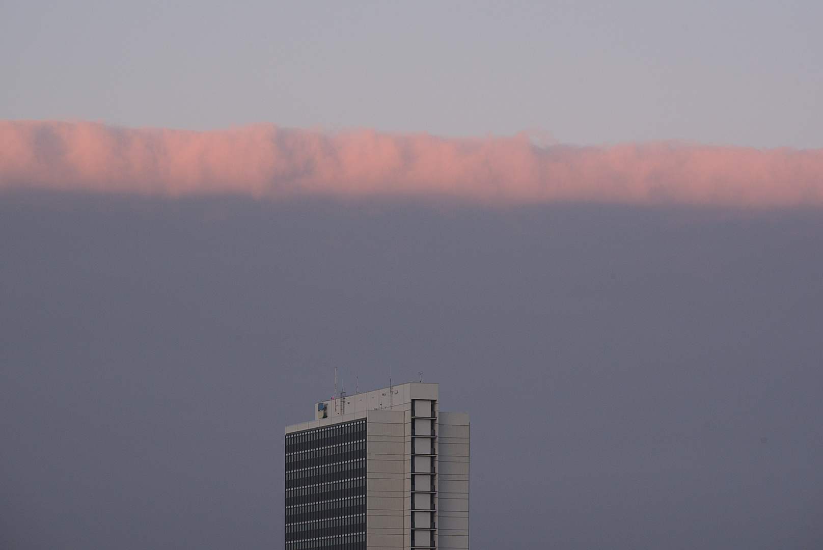 Abendlicht in den Wolken über einem Hochhaus