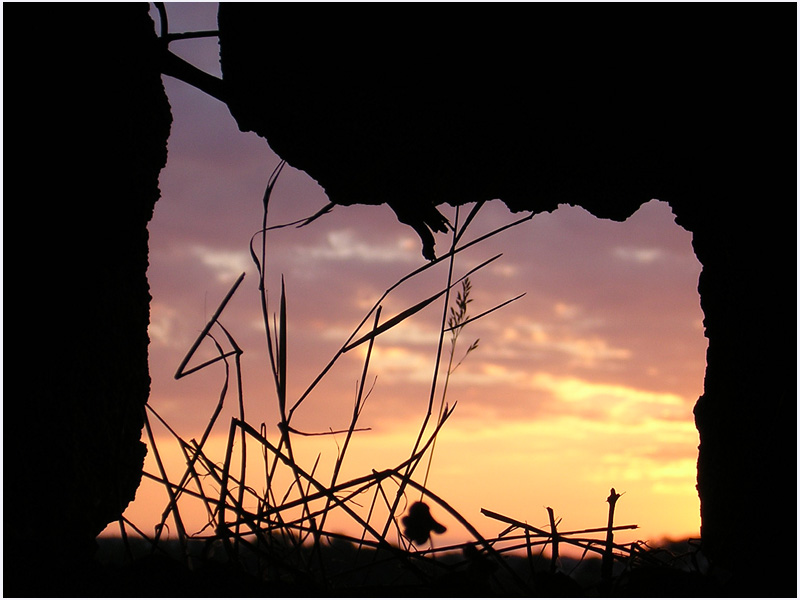 Abendstimmung durch ein kleines Loch der Burgmauer