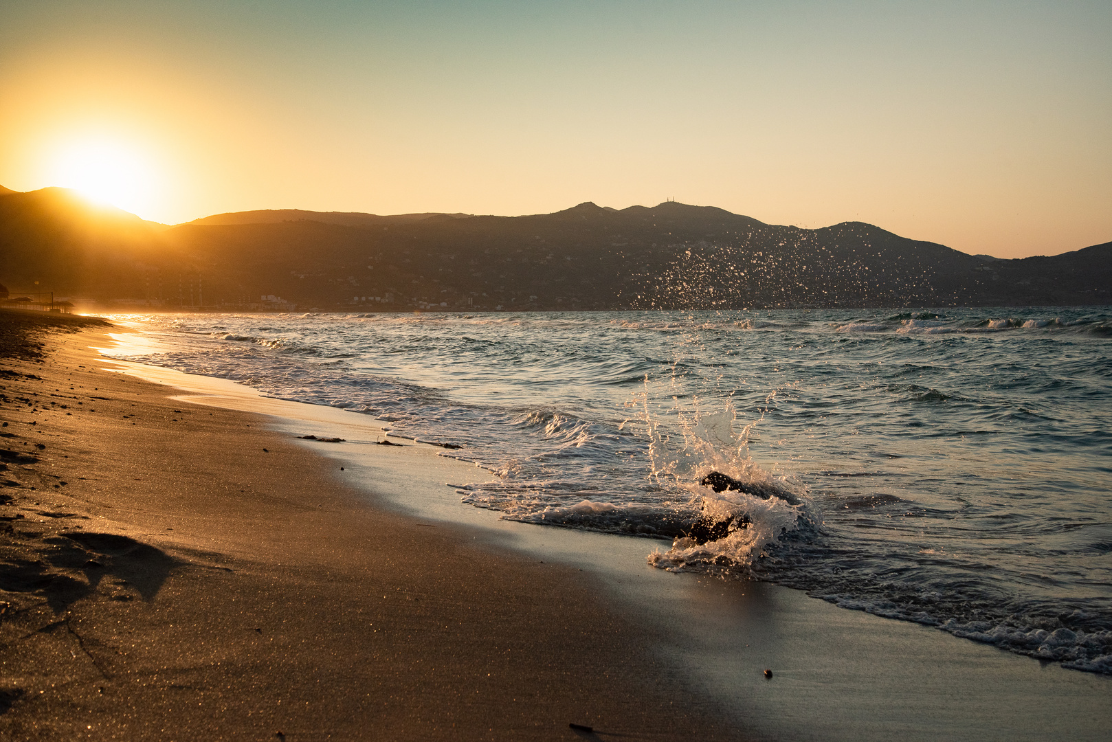 Abendstimmung mit Sonne, Bergen und Brandung auf Kreta