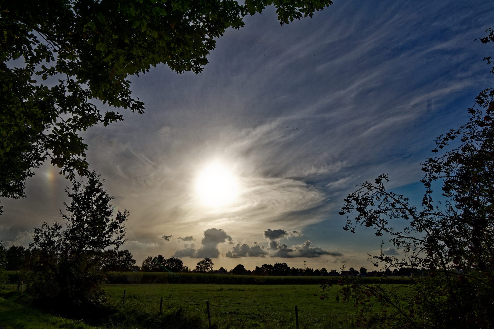 Abendstimmung mit Sonne, Nebensonne und Wolken