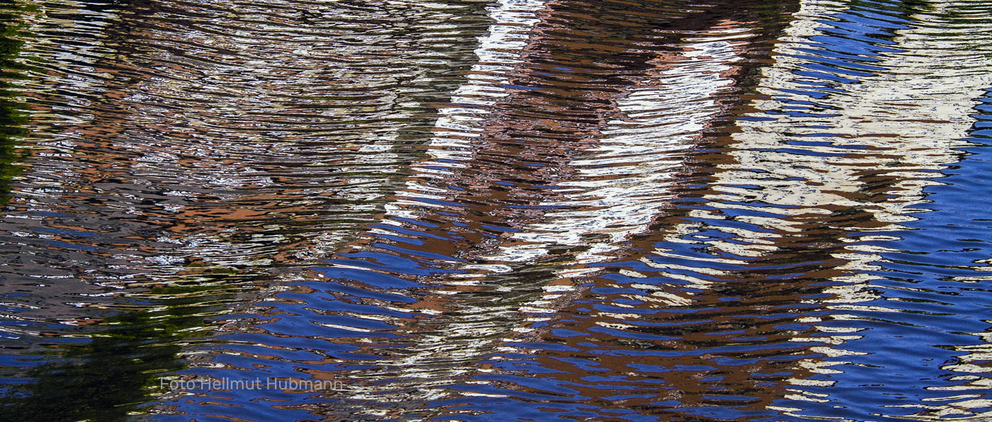 ABSTRAKTE SPIEGELEI MIT WELLEN UND UNTEREN HIMMELSDETAILS IN BLAU