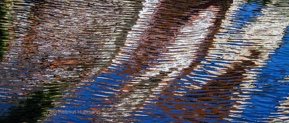 ABSTRAKTE SPIEGELEI MIT WELLEN UND UNTEREN HIMMELSDETAILS IN BLAU