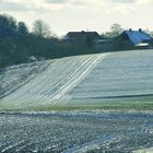 Äcker mit Schnee vor Häusern