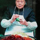 Ältere Frau in China beim Krautrouladen binden