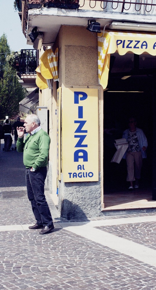 Älterer Herr vor einem Pizzaladen