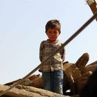 Afghanischer Junge auf den Trümmern des Hauses seiner Eltern