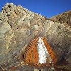 Agua termal brotando de la piedra