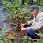 Allein im Wald, im Regen, ein Hirte wärmt sich am Feuer