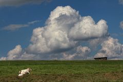 Alleinliegende Mutter mit Kind vor Wolkenhimmel