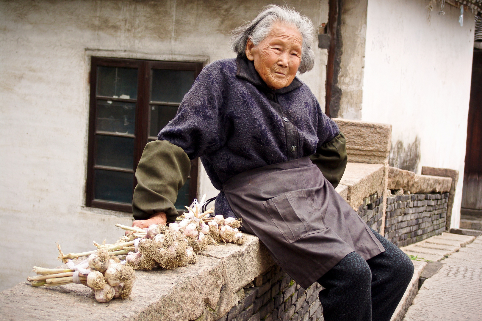 Alte Chinesin verkauft Knoblauch