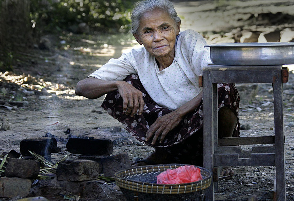 Alte Frau beim Kochen in Kambodscha