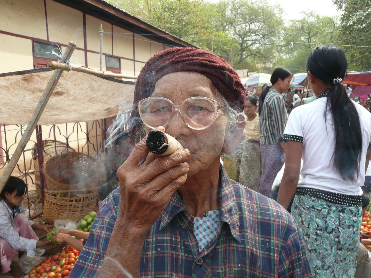 Alte Frau mit Cheroot-Zigarette in einem Ort bei Bagan