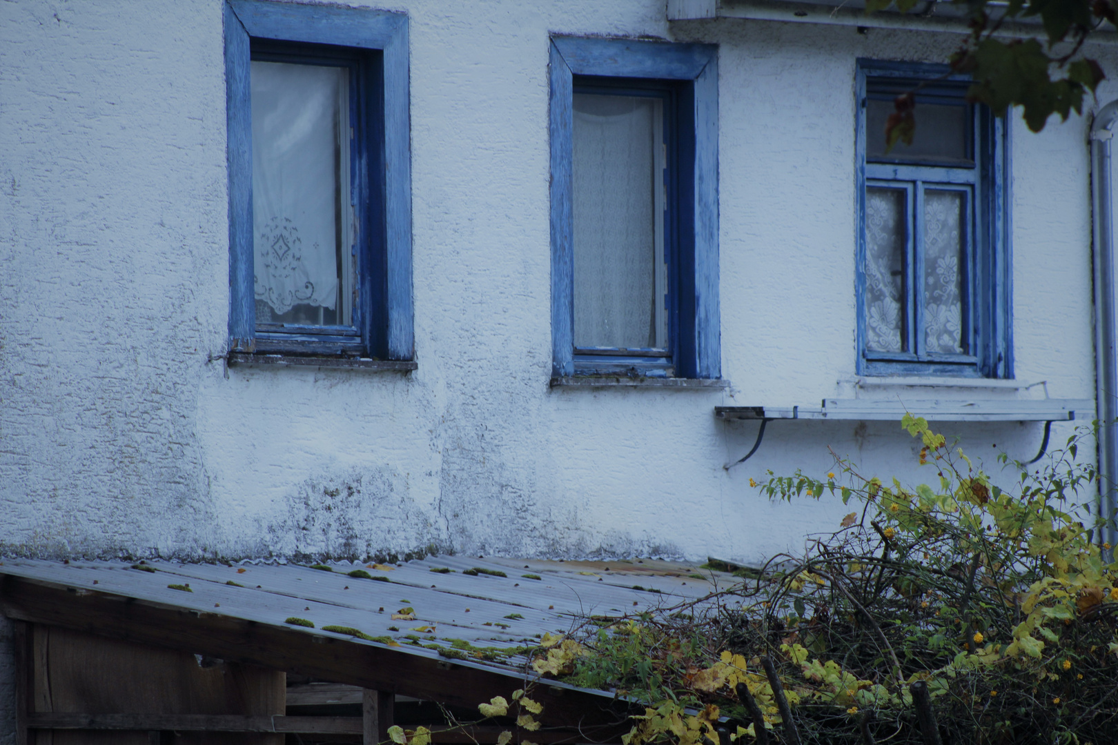 alte Häuser und am Fenster gehäkelte Gardinen 