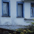 alte Häuser und am Fenster gehäkelte Gardinen 