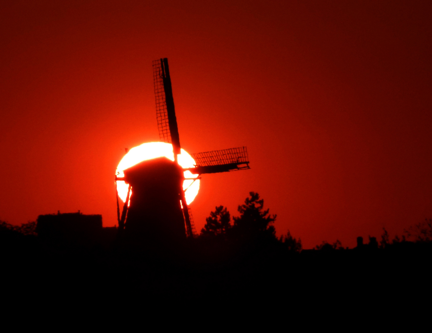 alte holländische Windmühle vor untergehender Sonne